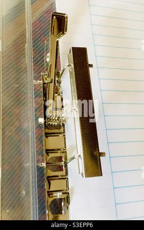 Old-style paper clamp with a lever. Elegant, one-step operation. Simple, effective. Concepts: simplicity, efficiency, best in class. Stock Photo