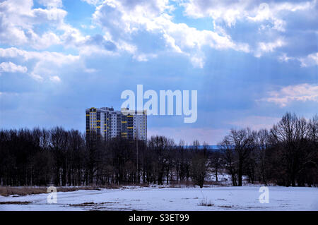 Tall house behind the trees in the rays of the spring sun Stock Photo