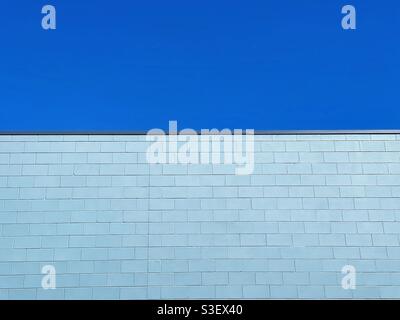 Blue painted brick wall against blue sky Stock Photo