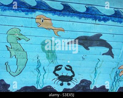 Cartoon Sea creatures painted on a blue background on a wooden wall Stock Photo