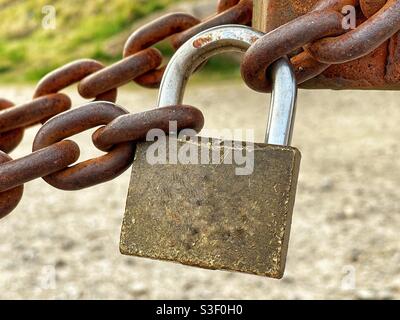 Close-up of a padlock securing a heavy metal chain Stock Photo