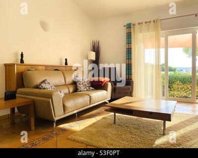Living room lit by golden sunlight coming through sliding glass doors Stock Photo