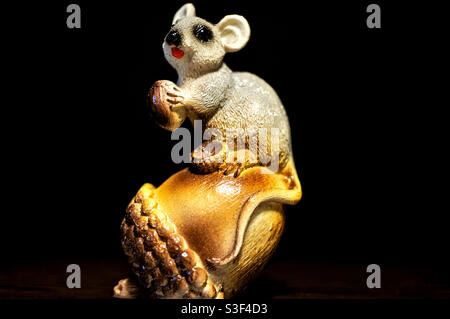Toy gray mouse sitting on a large acorn Stock Photo