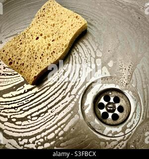 Cleaning stainless steel kitchen sink. Stock Photo