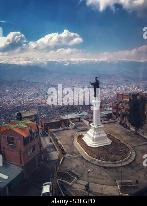 A religious Statue looks over La Paz, Bolivia from the neighboring city of El Alto Stock Photo