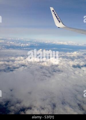 Aeroplane flying over the clouds with the Ryanair logo - off on holidays Stock Photo