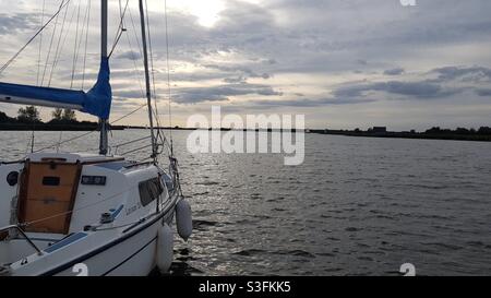Sailing into the sunset on calm waters. Stock Photo