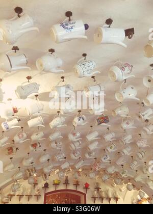 Collection of old-fashioned coffee pots hanging on the ceiling Stock Photo