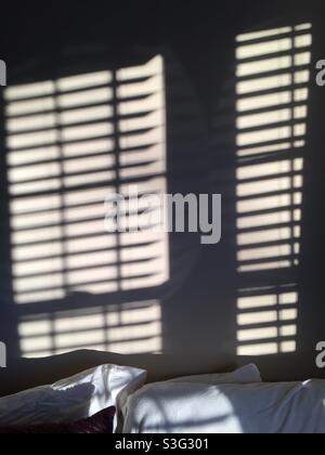 Morning light streams through the windows, producing shadows on the wall. Stock Photo
