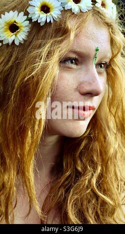 Girl with long hair and wreath of flowers in hair at music festival in England Stock Photo