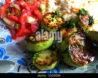 Spanish style fried garlic zucchini served with rice and salad Stock Photo