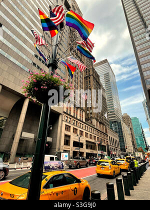 American and rainbow flags blowing in the wind at the taxi stand in front of Grand Central terminal on E. 42nd St., 2021, NYC, USA Stock Photo