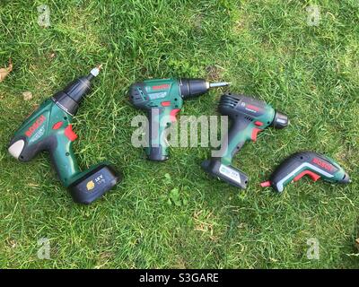 Four Bosch electric drills and screwdrivers of different sizes in the grass Stock Photo