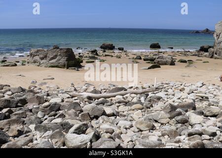 Stones and driftwood on the beach in Brittany Stock Photo