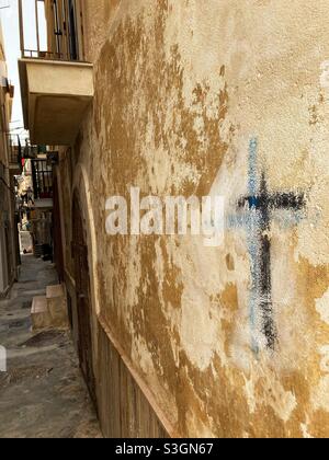 A Cross graffiti drawn on a Wall in an alley in Vieste, Puglia, Italy Stock Photo