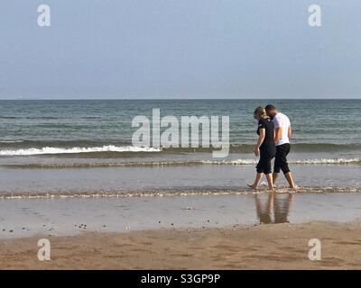 Togetherness: a couple waking on the beach Stock Photo