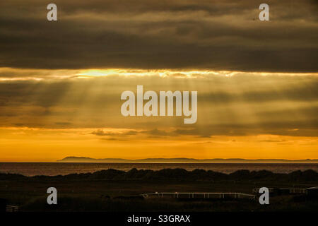 Sunset over Islay from Machrihanish on the Kintyre peninsula in Scotland Stock Photo