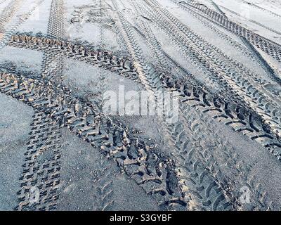Tire tracks in the sand on Castlecliff beach in New Zealand Stock Photo