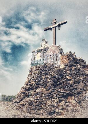 A cross and statue of Mary holding the body of Christ atop a mountain of gemstone architecture at the Grotto of the Redemption in West Bend, Iowa Stock Photo