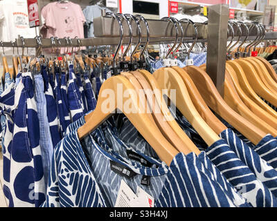 Clothes on display on a rack in a clothes shop. Stock Photo