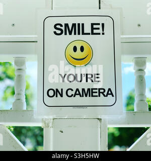 “SMILE! YOU’RE ON CAMERA” sign in an outdoor public area Stock Photo