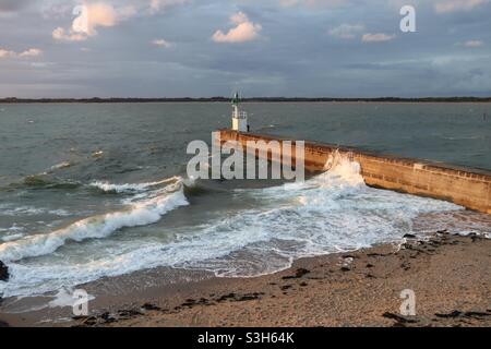 Waves splashing on the pier at sunset in Merquel, Loire Atlantique department in France on summer 2021 Stock Photo