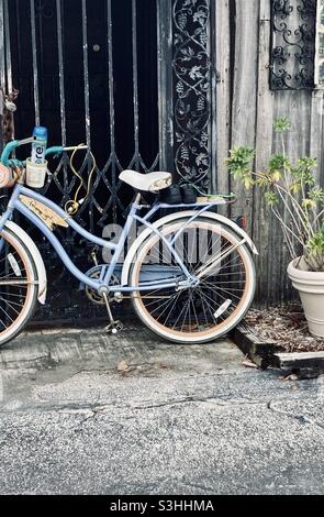 Blue  bicycle leaning on a gate Stock Photo