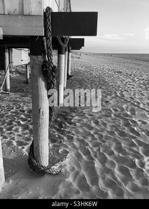 on the beach a strong rope is wrapped around the wooden pole of a beach ...