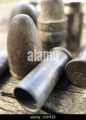 Old bullets and shell casings on a piece of wood. Stock Photo