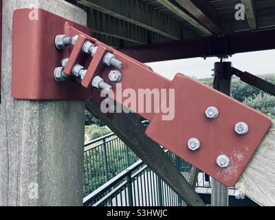 red metal frame is fixed with gray metal screws and nuts Stock Photo