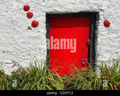 Red door of an old cottage in Port Magee, County Kerry, Ireland. Stock Photo