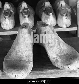 Shelves of shoe lasts in a cobblers workshop in black and white Stock Photo