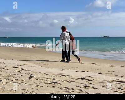 Middle aged couple walking along a sandy beach Stock Photo