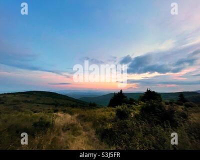 A trail winds up the steep grasslands above Grayson highlands state park in Virginia at sunset. Stock Photo