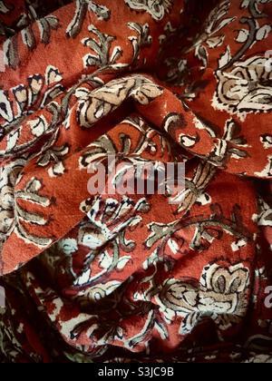 close up image of a crumpled piece of orange material with sketched flower and leaf motifs Stock Photo