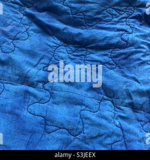 Blue quilt with curved stitching Stock Photo