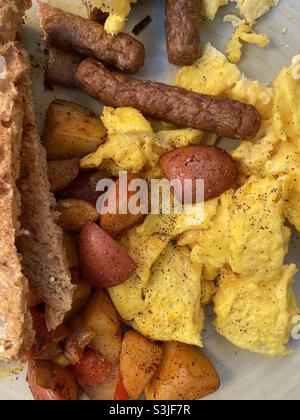 Typical American breakfast of scrambled eggs, home fries, sausage and toast. Stock Photo