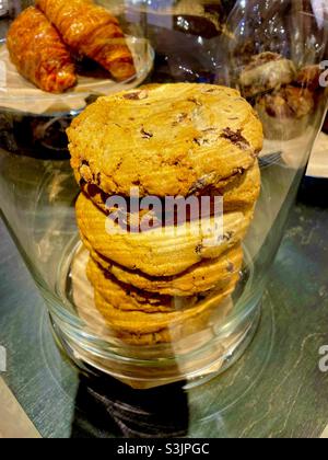 A stack of golden chocolate chip cookies in a glass jar Stock Photo