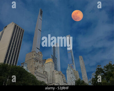 A full moon rising over super tall condominiums in midtown Manhattan on a clear evening, 2021, NYC, USA Stock Photo