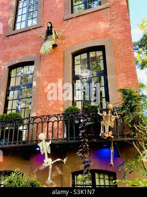Halloween skeleton decorations climbing up a building in New York City Stock Photo