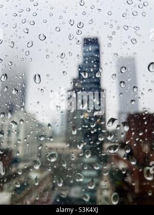 Raindrops on the window with the blurred background of New York City skyscrapers Stock Photo