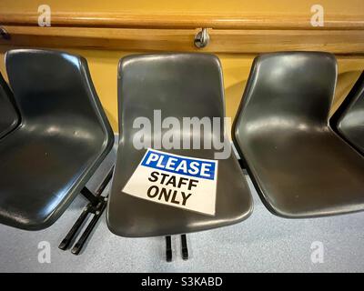 A staff only sign on plastic chairs Stock Photo