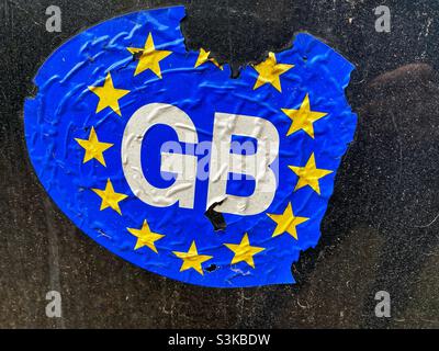 A worn GB car sticker on the back of a car. The Great Britain (GB) sticker is no longer valid and has been replace by one which says ‘UK’ Stock Photo