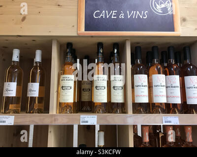Wine bottles on shelves in wine store in France Stock Photo