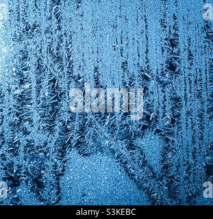 A frosted window covered in tiny icicles Stock Photo