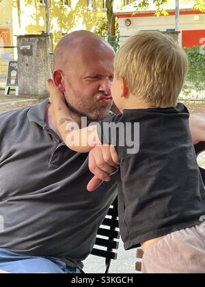 A father making funny faces for his toddler Stock Photo