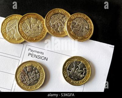 One pound coins on top of an anonymous pension payment slip Stock Photo