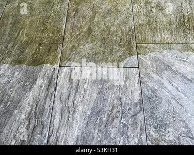 Contrast between clean and dirty paving slabs after pressure washing. Stock Photo