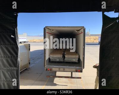 Semi truck loaded with pallets of paper products is seen backing up to a dock for unloading in Utah, USA. Stock Photo