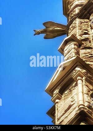 A gargoyle peers down from its’ perch high up on the Medieval styled Cathedral of the Madeleine in Salt Lake City, Utah, USA. Stock Photo